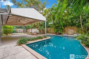 Key Biscayne house for rent - A pool area with a canopy and a wooden fence.