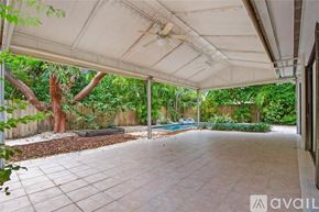 Key Biscayne house for rent - A patio area with a white canopy and a pool in the background.