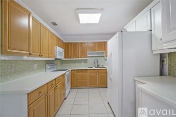 Key Biscayne house for rent - A kitchen with wooden cabinets and a white refrigerator.