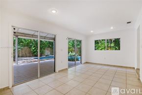Key Biscayne house for rent - A spacious room with sliding glass doors leading to a backyard.