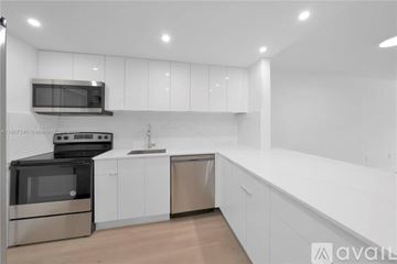 Key Biscayne apartment for rent - A modern kitchen with white cabinets and stainless steel appliances.