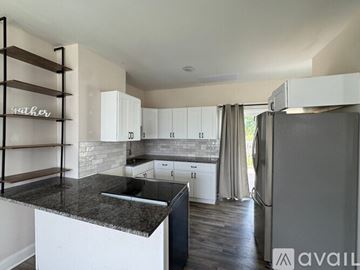 Columbus house for rent - A modern kitchen with white cabinets and a black island.