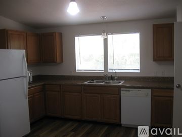Orlando house for rent - A kitchen with wooden cabinets and a white dishwasher.