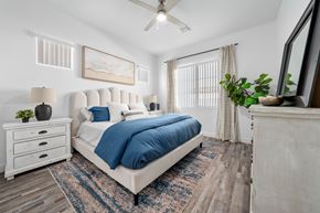 Phoenix apartment for rent - A bedroom with a large bed  with a blue duvet cover, two nightstands, a large window and a ceiling fan at Allero 59 Apartments, Arizona, 85035