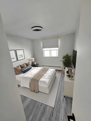Acton apartment for rent - A bedroom with a bed, a window, a plant, and a TV.