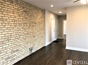 Chicago apartment for rent - A room with a brick wall and wooden flooring.