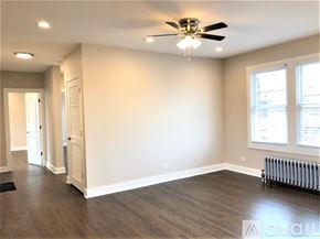 Chicago apartment for rent - A spacious room with a ceiling fan and a radiator on the wall.