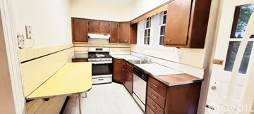 Washington house for rent - A kitchen with brown cabinets and a yellow counter.