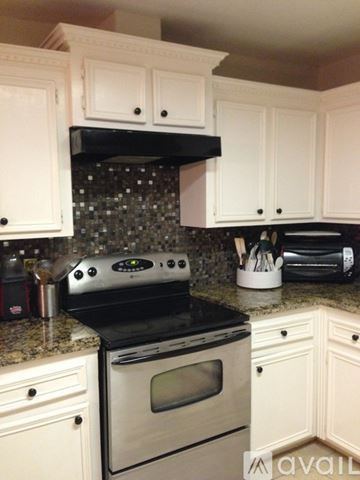 Los Fresnos house for rent - A kitchen with white cabinets and a black stove top oven.