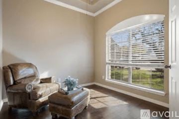 Austin house for rent - A living room with a brown leather chair and ottoman.