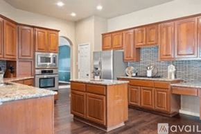 Austin house for rent - A kitchen with wooden cabinets and a granite counter top.