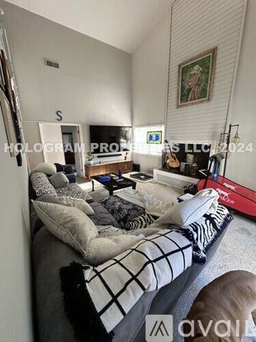 San Luis Obispo apartment for rent - A living room with a couch, a coffee table, a guitar, and a painting on the wall.