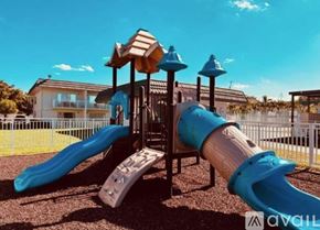 Miami Gardens apartment for rent - A playground with a blue slide and a wooden structure.
