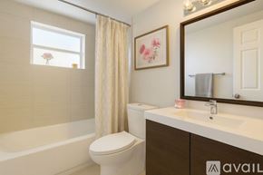Miami Gardens apartment for rent - A large outdoor swimming pool surrounded by a brick patio and a white fence.