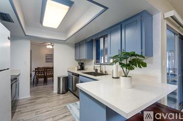 Tempe house for rent - A kitchen with a white counter top and blue cabinets.