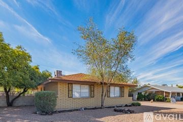 Tempe house for rent - A living room with a blue chair and a grey couch.