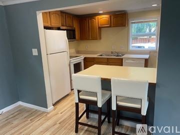 Rome house for rent - A kitchen with a white refrigerator and wooden cabinets.