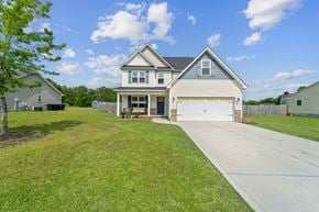 Jacksonville house for rent - A two-story house with a garage is surrounded by a well-maintained lawn.