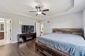 Jacksonville house for rent - A bedroom with a bed, a television, and a ceiling fan.