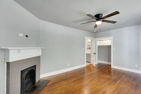 Spartanburg house for rent - A room with a fireplace and a ceiling fan.