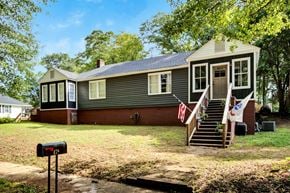 Spartanburg house for rent - A house with a grey siding and a brown roof with a mailbox in front.