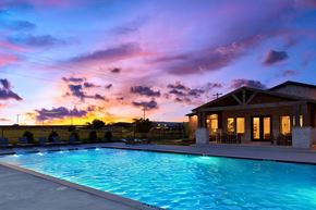 Greenville apartment for rent - A pool with a house in the background during sunset.