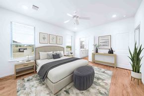 Greenville apartment for rent - A bedroom with a large bed and a ceiling fan.