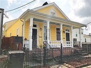 New Orleans apartment for rent - A yellow house with a black fence in front.
