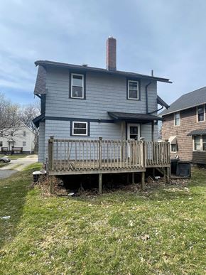 Akron house for rent - A house with a grey exterior and a wooden deck.