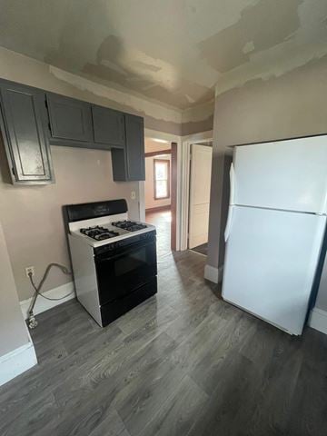 Akron house for rent - A kitchen with a white fridge and a black stove top oven.