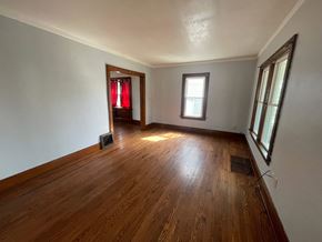 Akron house for rent - A room with wooden floors and white walls.