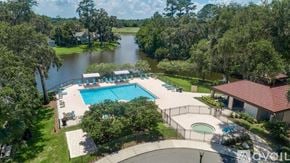 Ponte Vedra Beach house for rent - A large outdoor pool surrounded by a fence and trees.