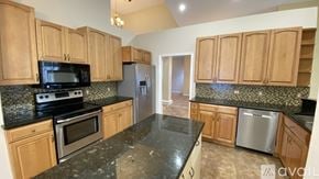 Ponte Vedra Beach house for rent - A kitchen with wooden cabinets and black countertops is available for rent.
