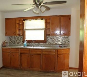 Louisville house for rent - A kitchen with wooden cabinets and a fan on the ceiling.