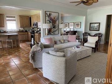 Fairhope house for rent - A living room with a grey couch and a brown tiled floor.
