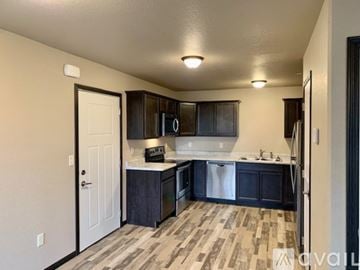 Box Elder apartment for rent - A kitchen with dark wood cabinets and a white door.