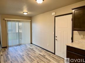 Box Elder apartment for rent - A room with a tiled floor, a window with blinds, a white door, and a cabinet.