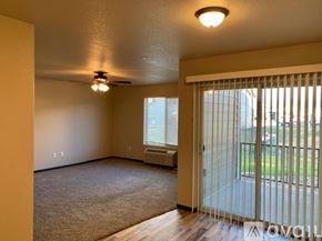 Box Elder apartment for rent - A room with a ceiling fan and sliding glass doors.