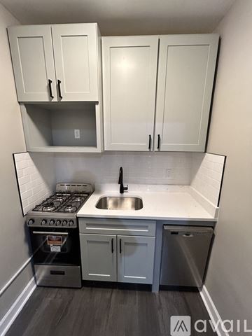 Hammond apartment for rent - A kitchen with white cabinets and a stove top oven.