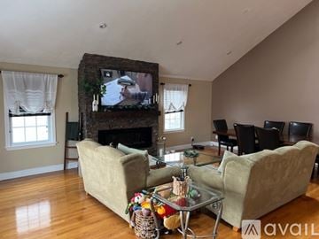 Revere townhouse for rent - A living room with a fireplace and a television on the wall.