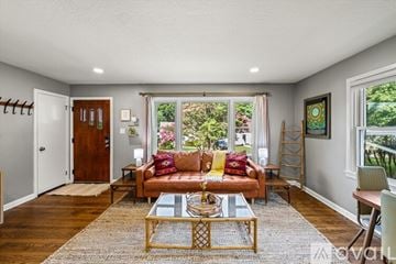 Knoxville house for rent - A living room with a couch, coffee table, and a window with a view of the backyard.