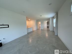 Parrish house for rent - A spacious room with marble flooring and white walls.