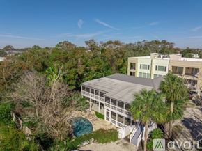 Tybee Island house for rent - A house with a pool surrounded by trees.