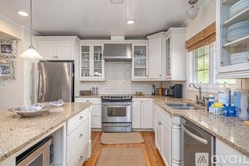 Tybee Island house for rent - A kitchen with white cabinets and a granite countertop.