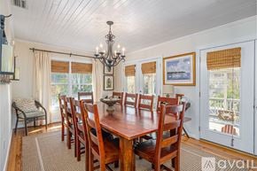 Tybee Island house for rent - A dining room with a wooden table and chairs.
