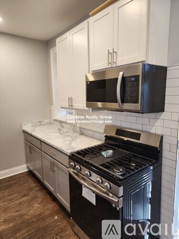 Chicago apartment for rent - A kitchen with a stove top oven and microwave above it.