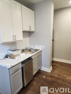 Chicago apartment for rent - A kitchen with white cabinets and a wooden floor.