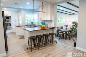Los Angeles house for rent - A kitchen with a bar area and a dining table.