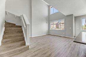 Spruce Grove apartment for rent - A spacious living room with a staircase leading to the upper floor.