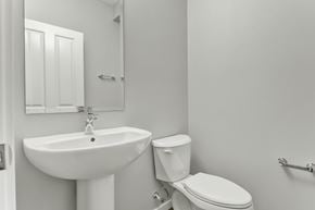 Spruce Grove apartment for rent - A white bathroom with a toilet, sink, and towel rack.